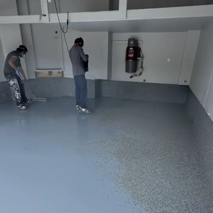 Fēnix Finish crew rolling an epoxy topcoat over a flake garage floor