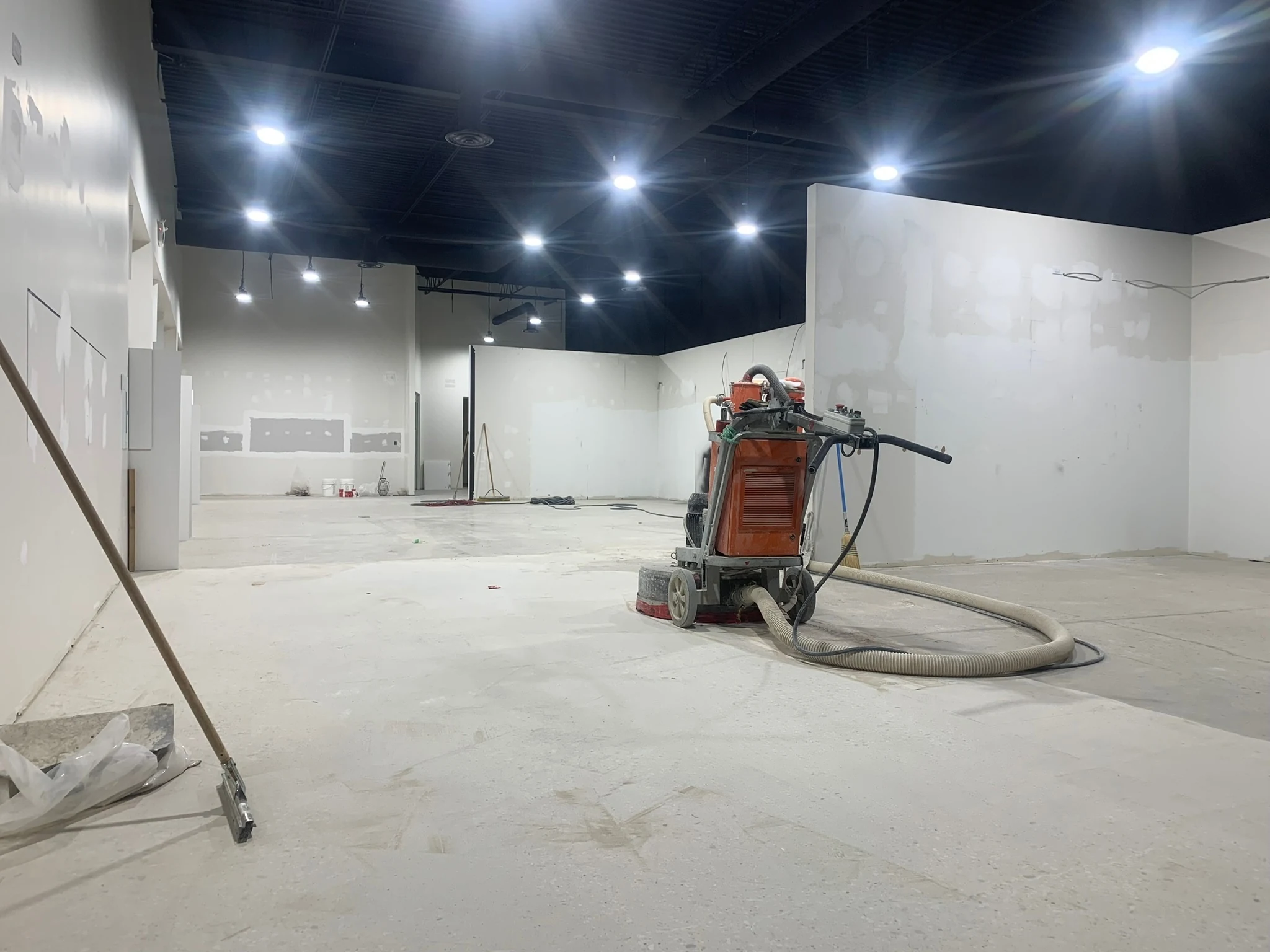 Fēnix Finish grinder and dust extractor preparing a bare concrete slab
