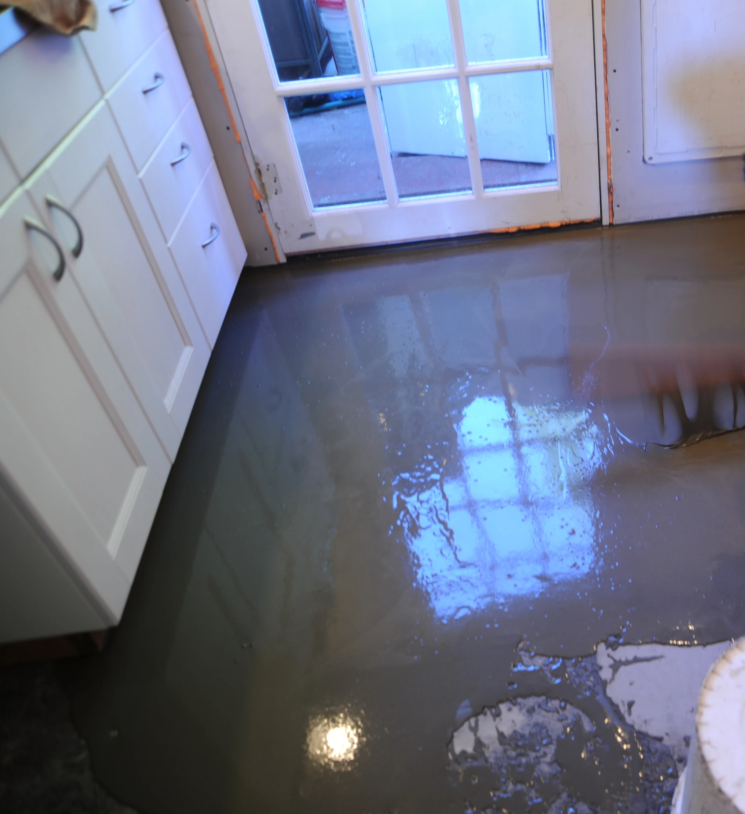 Freshly poured self-levelling cement over a kitchen floor